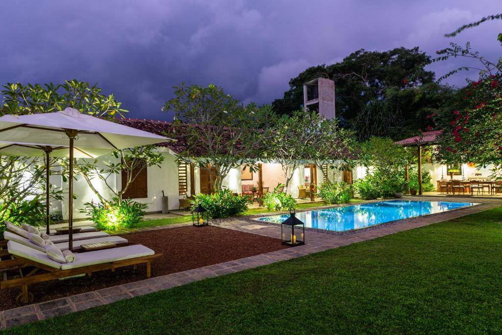 a backyard with a swimming pool and a villa at Nyne Hotels Rock Villa, Bentota in Bentota