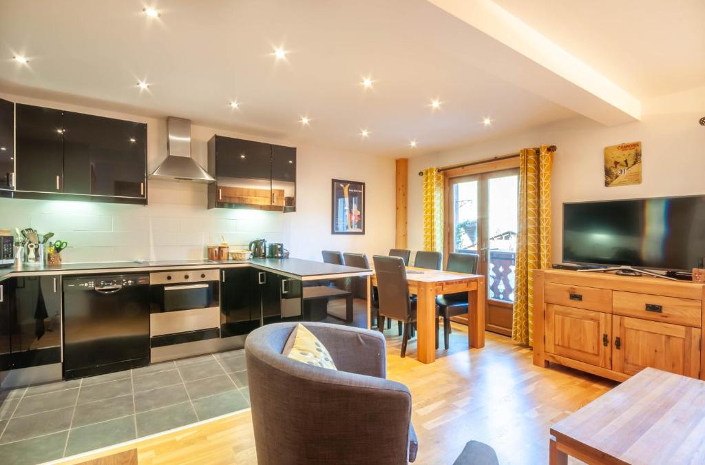 Il comprend une cuisine et une salle à manger avec une table à manger. dans l'établissement Christiania 4, à Morzine