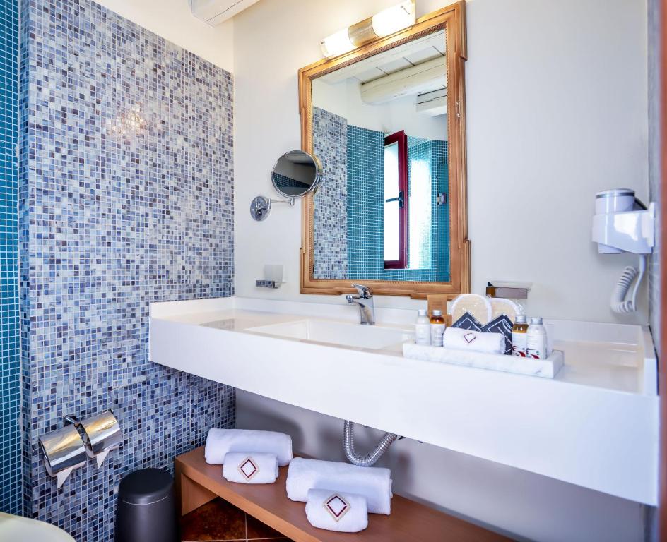 a bathroom with a sink and a mirror at Varos Village Boutique Hotel in Város