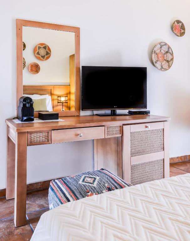 a bedroom with a desk with a tv and a mirror at Varos Village Boutique Hotel in Város