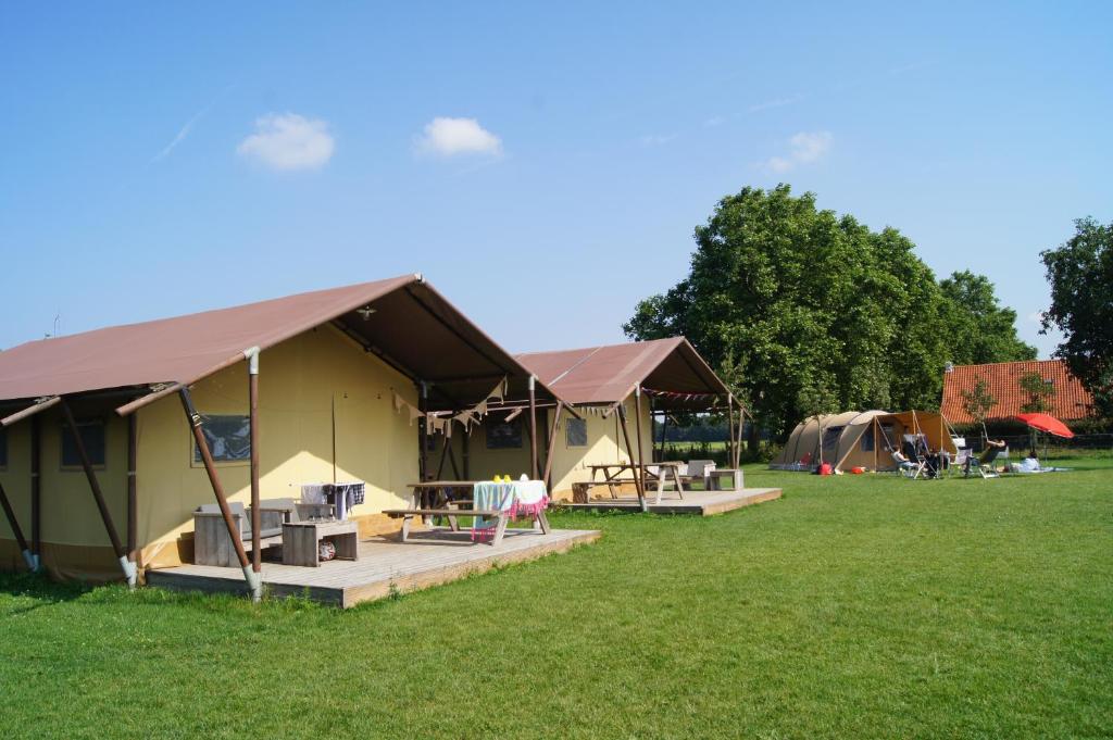 a group of tents in a grass field at Hoeve Linnerveld XL in Sint Odiliënberg