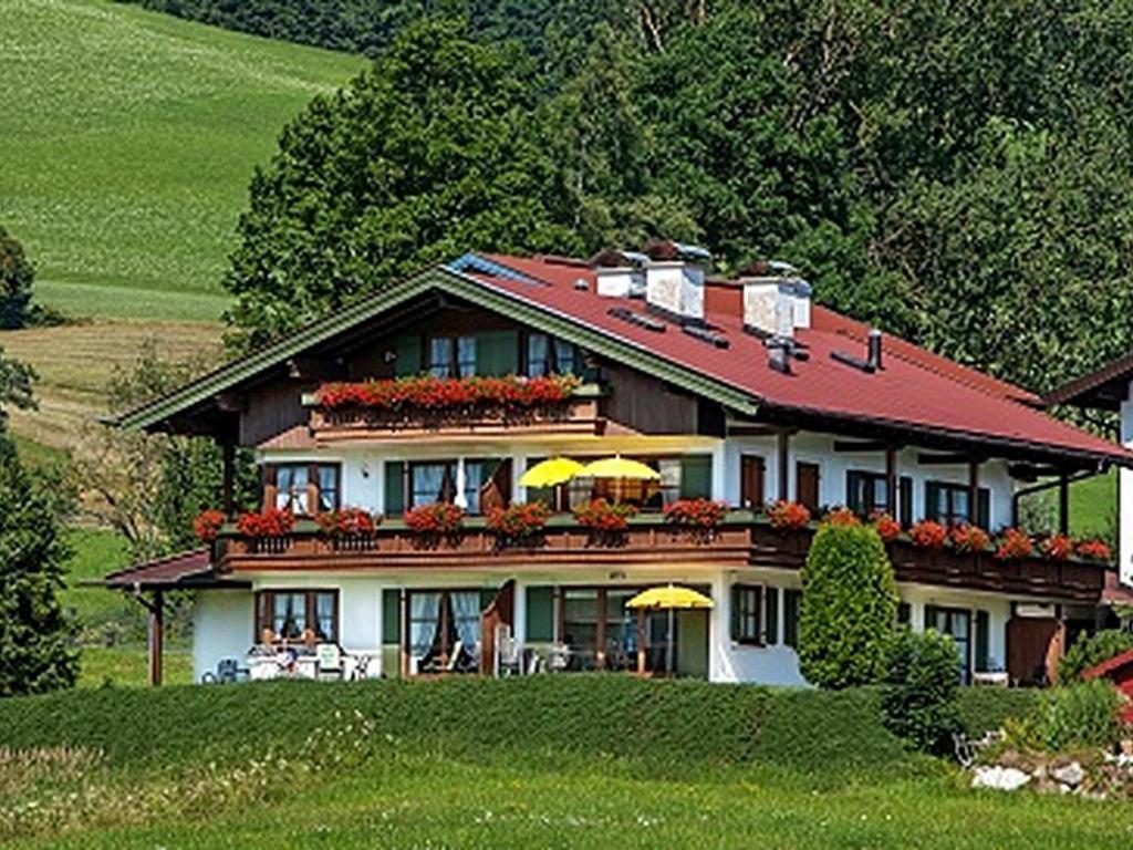 ein großes Haus auf einem Hügel mit in der Unterkunft Ferienwohnung Froböse in Reit im Winkl