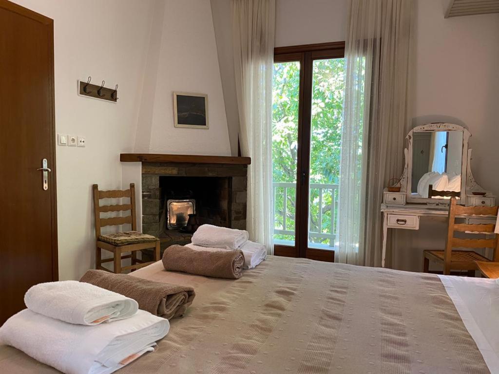 a bedroom with a large bed and a fireplace at Delux house in Tsangarada in Tsagarada