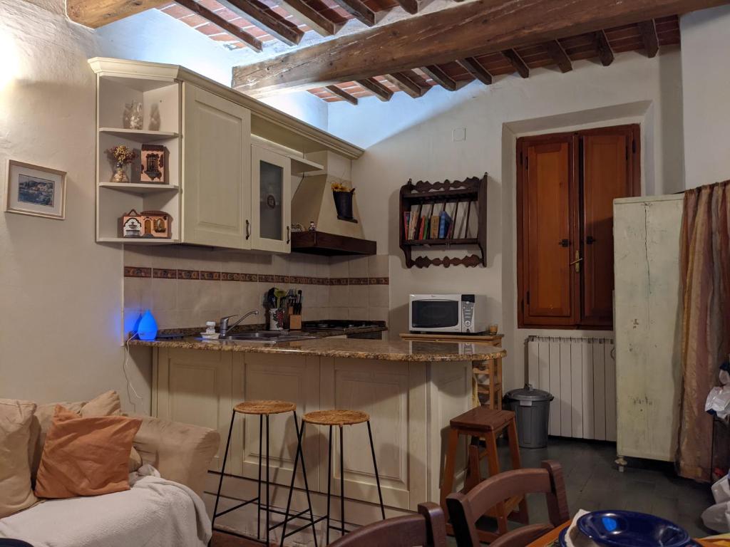 - une cuisine avec un comptoir et des tabourets dans une pièce dans l'établissement Casa Baldecchi - Pistoia Centro Storico, à Pistoia