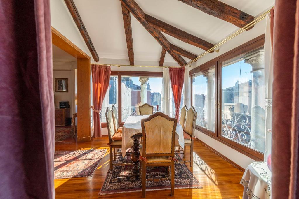 a dining room with a table and large windows at Palazzo Gradenigo in Venice