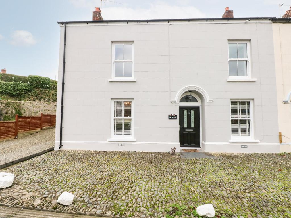 a white house with a black door at The Old Bakery in Tenby