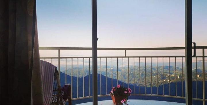a room with a view of the mountains from a window at The Cliff Resort, Munnar in Munnar