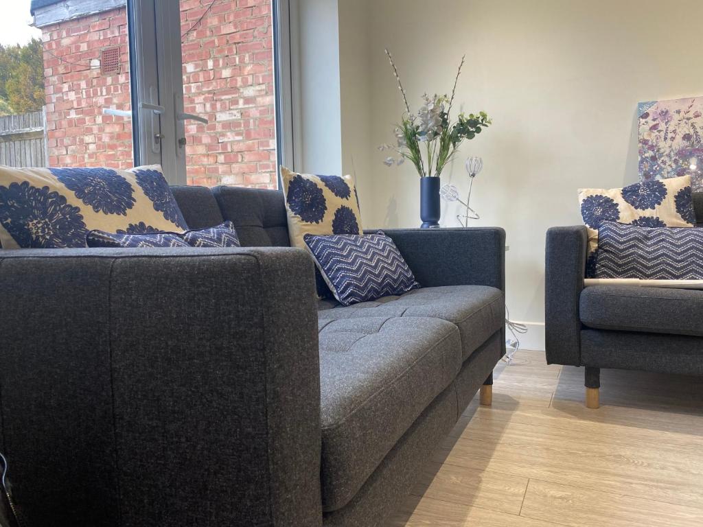 ein Wohnzimmer mit einem Sofa und 2 Stühlen in der Unterkunft Gladstone Apartments by Bluebell Rooms in Southampton