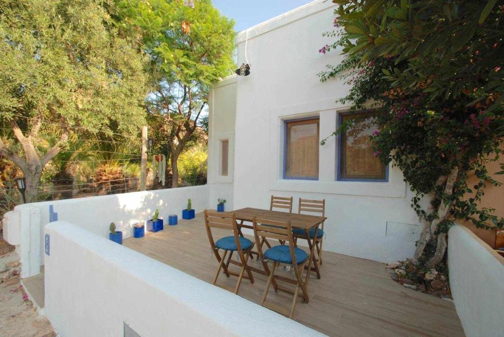 una mesa de madera y sillas en una terraza de madera en La Sirena Azul de Rodalquilar, en Rodalquilar