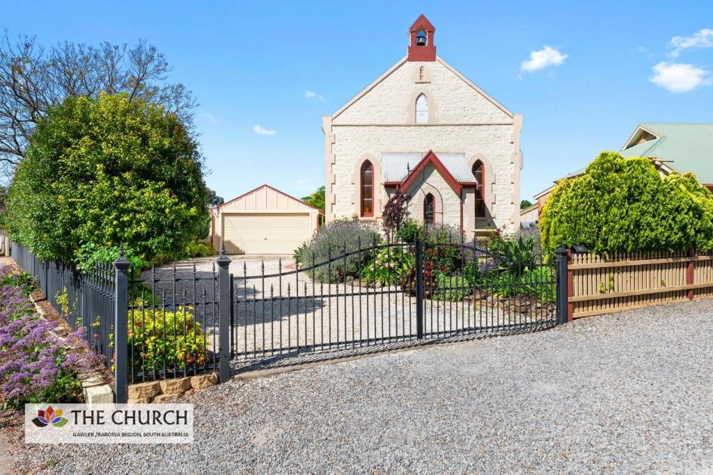 una iglesia con una valla negra delante de una iglesia en 'THE CHURCH' Guest Home, Gawler Barossa Region, en Willaston