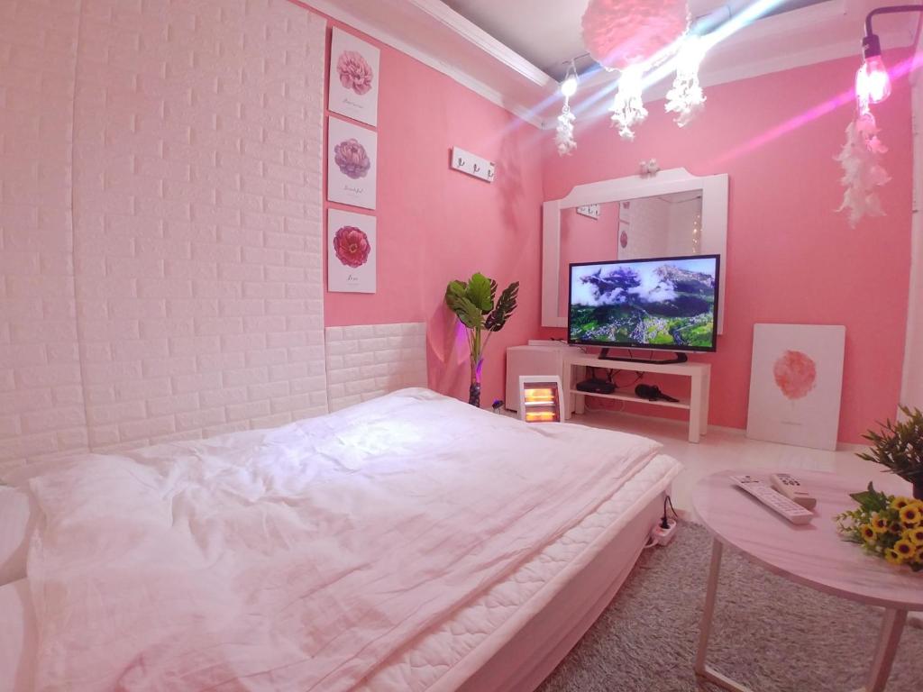 a bedroom with a bed and a table and a tv at Spring Light in Seoul