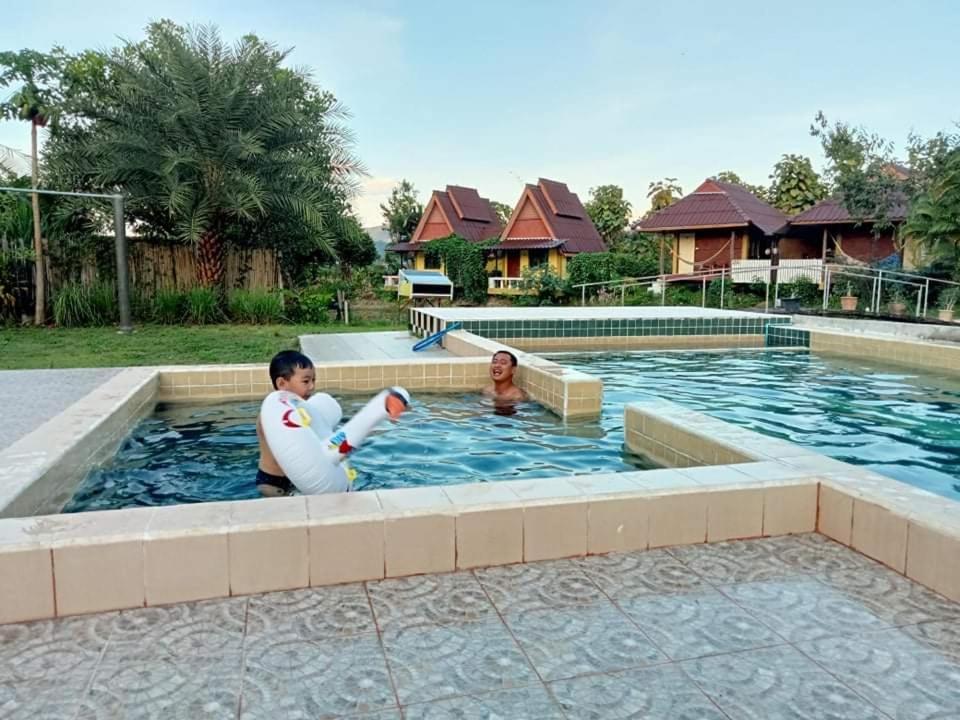 a man and a woman playing in a swimming pool at JJ&J Garden in Pai