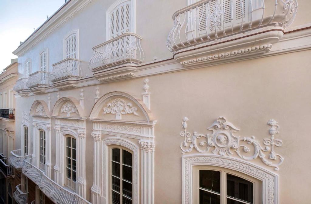 a white building with a balcony on the side of it at Áurea Casa Palacio Sagasta by Eurostars Hotel Company in Cádiz
