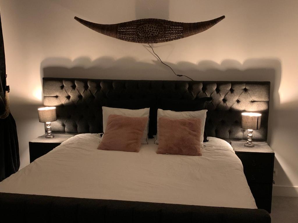 una camera con un grande letto con due lampade di Appartement op Italiëlei ad Anversa