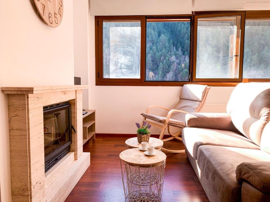 sala de estar con sofá y chimenea en Apartamento moderno Estanyó con vistas en Arinsal, en Mas de Ribafeta