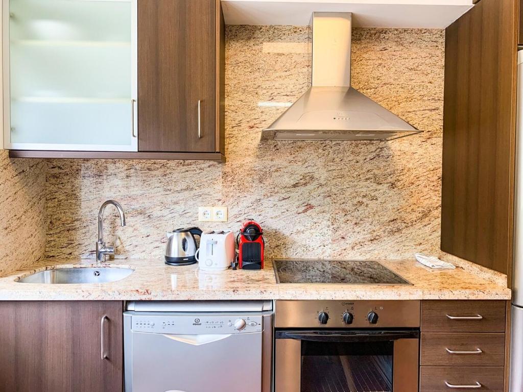 cocina con fregadero y fogones horno superior en Apartamento moderno Estanyó con vistas en Arinsal, en Mas de Ribafeta
