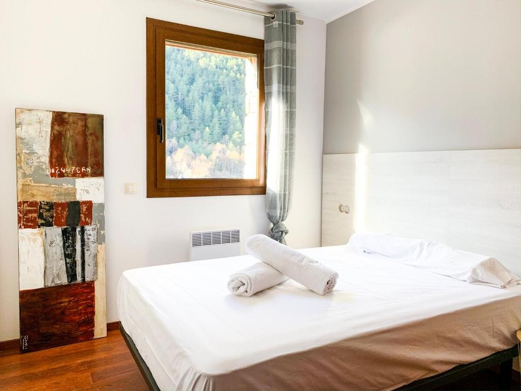 1 dormitorio con 1 cama blanca y ventana en Apartamento moderno Estanyó con vistas en Arinsal, en Mas de Ribafeta