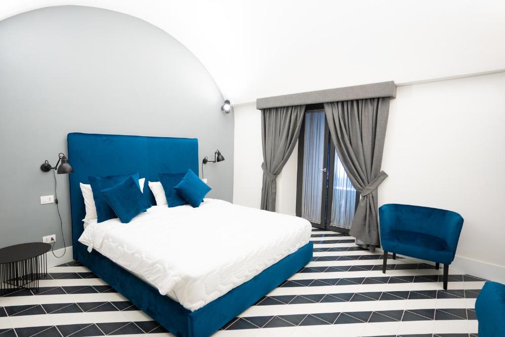 una camera con un letto blu e una sedia blu di Pulcinella Suite a Napoli