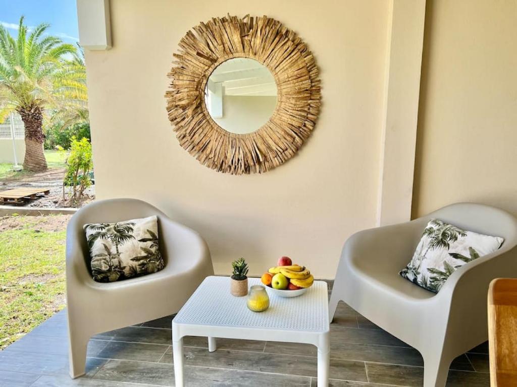 - un salon avec deux chaises et un miroir dans l'établissement Maracuja 4, Orient Bay village, walkable beach at 100m, à La Baie-Orientale