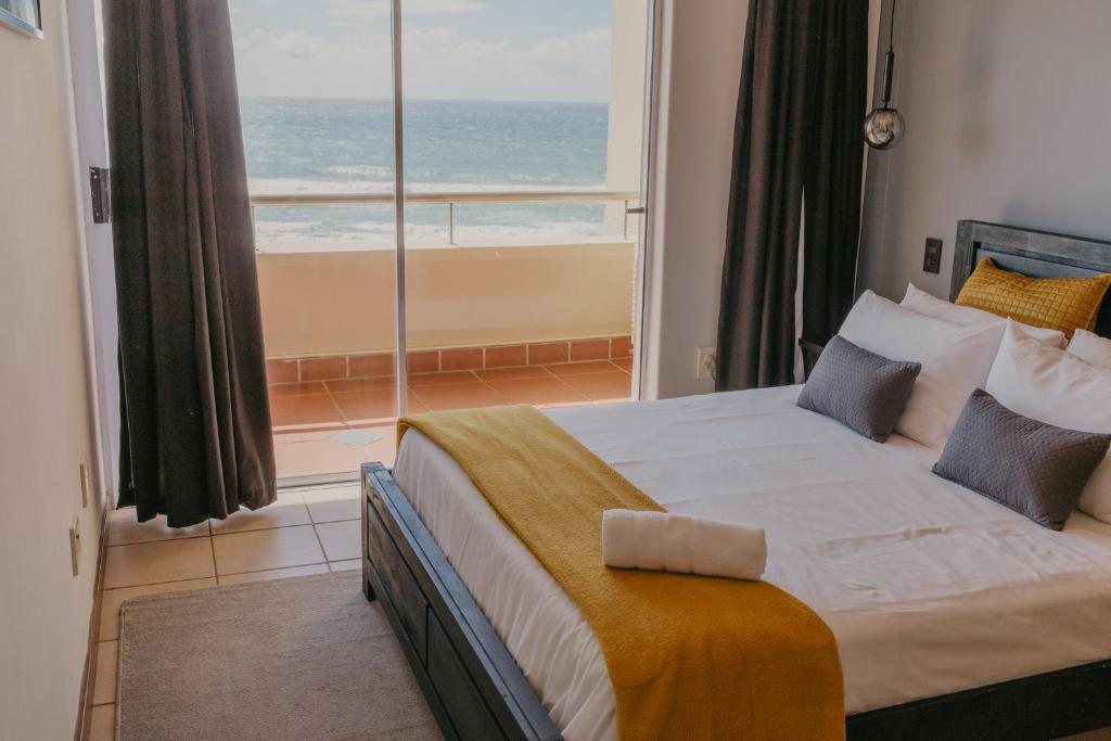 a bedroom with a large bed with a view of the ocean at Lescalier Cabanas 511 in Amanzimtoti