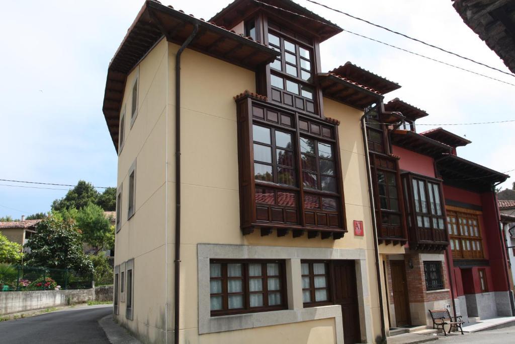 un edificio con ventanas negras y marrones en una calle en Apartamentos Los Picos, en Bricia