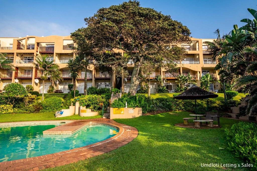 an apartment complex with a swimming pool and a resort at Twin Tide Duplex in Umdloti