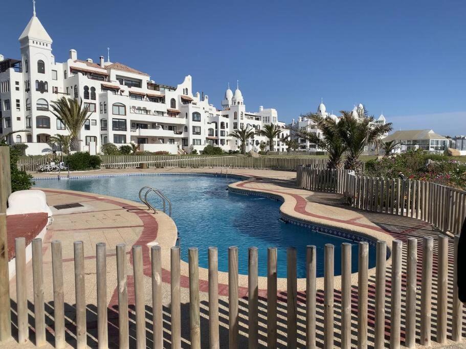 una piscina con una valla frente a un edificio en Bahía de Rosas frente al mar Algarrobo Norte, en Algarrobo