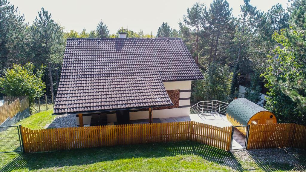 une petite maison avec un toit sur l'herbe dans l'établissement Ferienhaus in Niederösterreich mit 3 Apartments mitten im Wald, à Feichtenbach