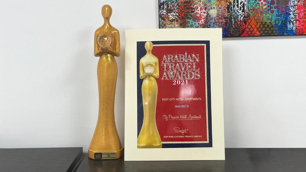 a golden trophy next to a poster and a picture at City Premiere Hotel Apartments - Dubai in Dubai