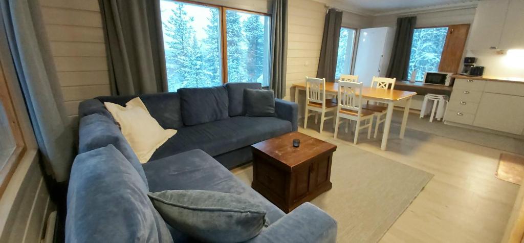 a living room with a blue couch and a table at Hillside Cottage in Ivalo