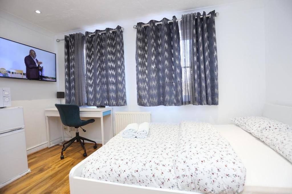 een slaapkamer met een bed, een bureau en een stoel bij Fabulous Room with en-suite bathroom and shared kitchen in Thamesmead