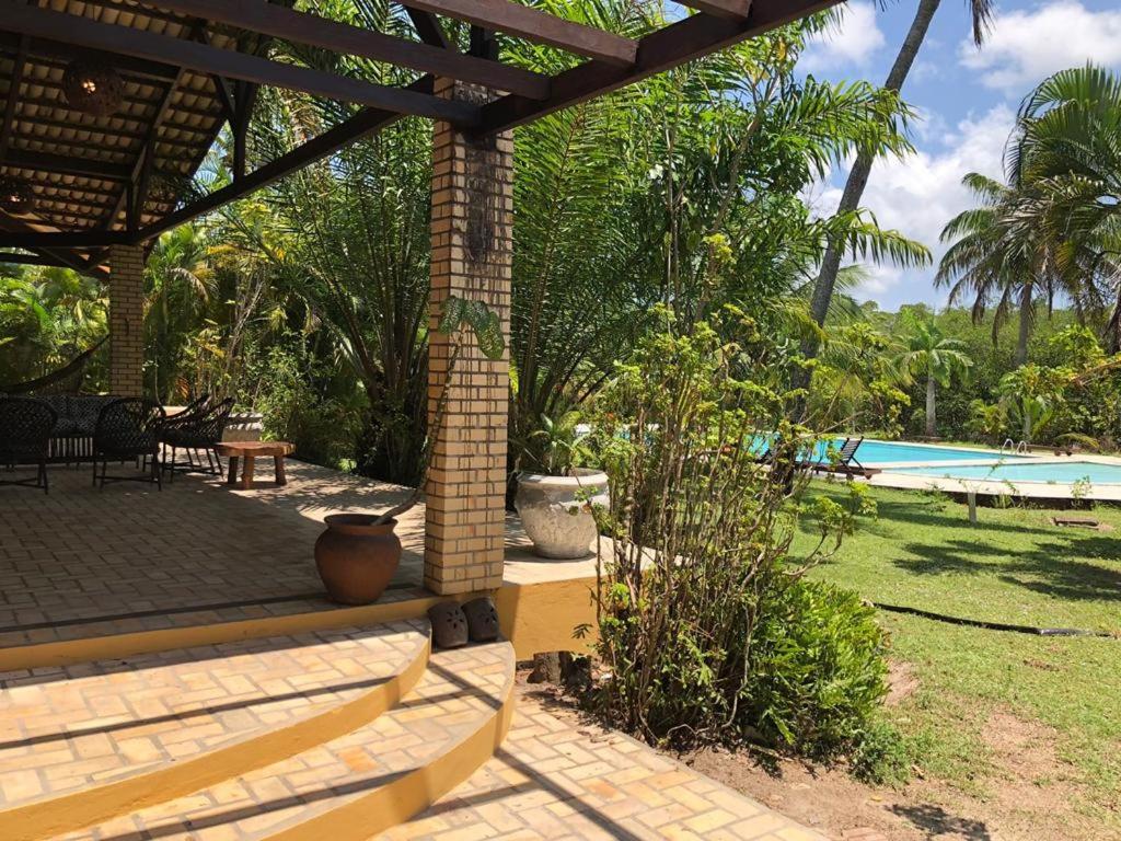 un patio avec une table et une piscine dans l'établissement Holiday Villa Praia da Pipa-5 Suites,Areá Gourmet by PipaCharme, à Pipa