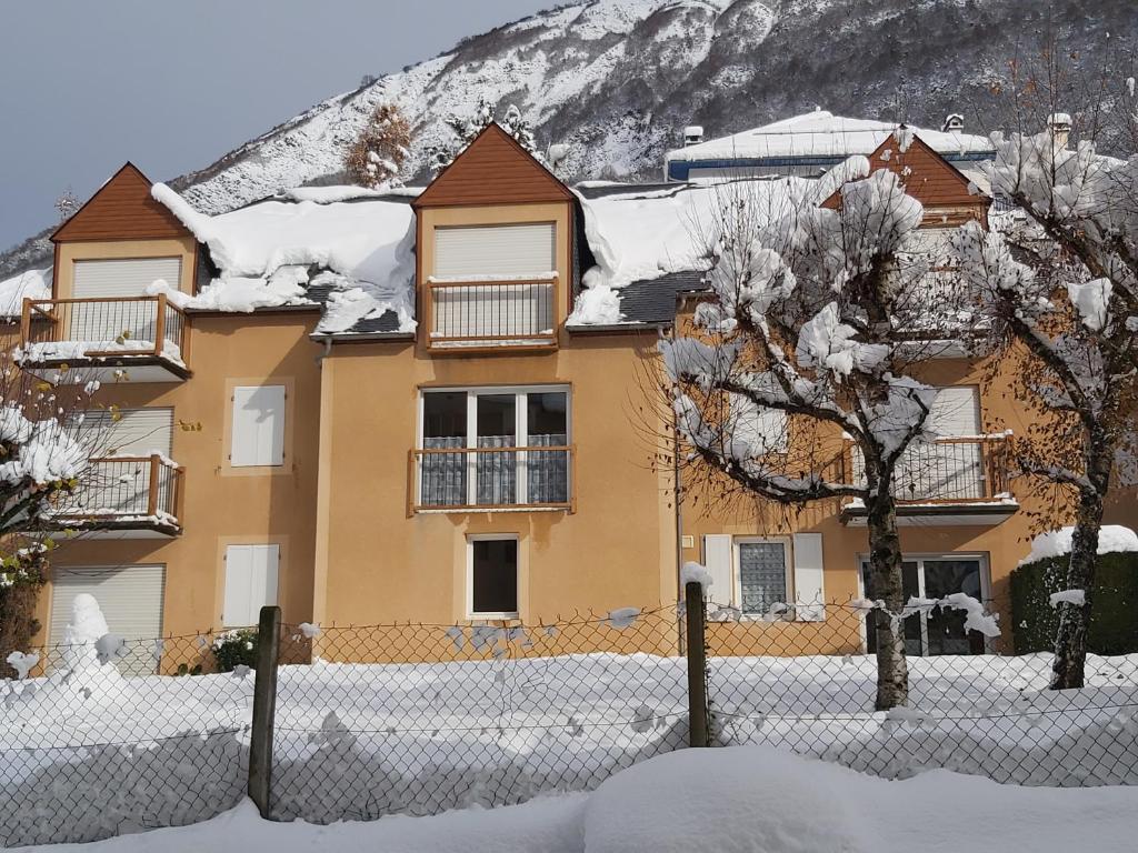 a house covered in snow in front of a mountain at Luz St Sauveur, Appartement 3 personnes, vue montagne, exposé sud, Résidence très calme in Luz-Saint-Sauveur