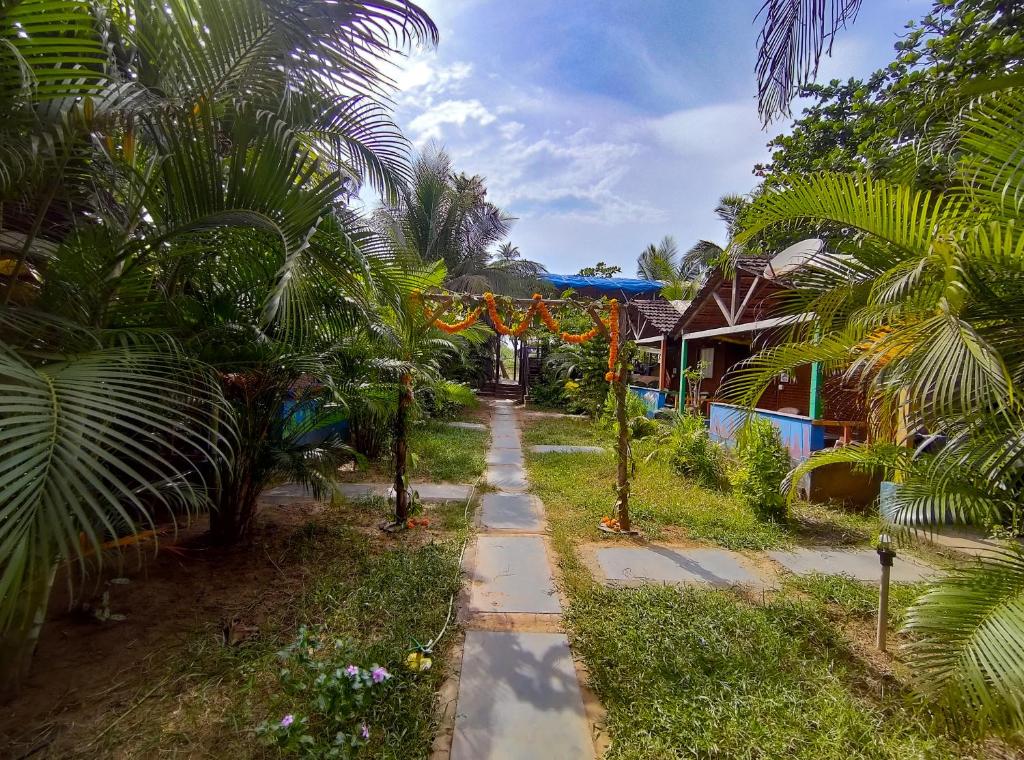 a path in front of a house with palm trees at Secret Garden Arambol in Arambol