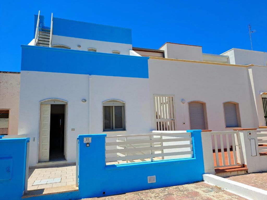 una casa azul y blanca con una puerta en Casa Luigi a 400m Dalla Sabbia en Lido Marini