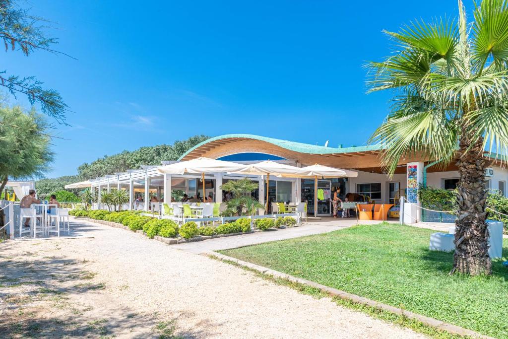 un resort con una palma di fronte di Camping Marelago a Caorle