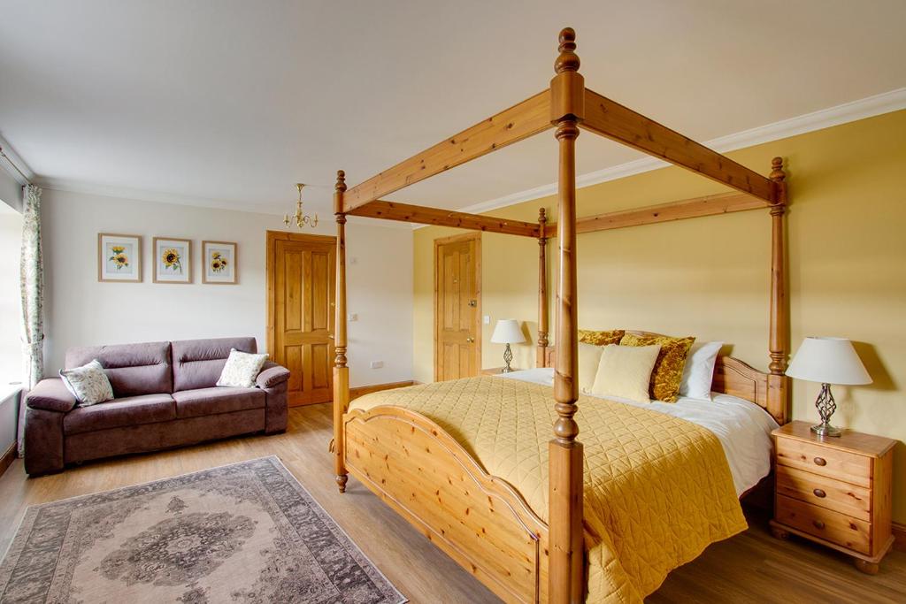 a bedroom with a canopy bed and a couch at Home Farm B&B - Sunflower Room in Forfar