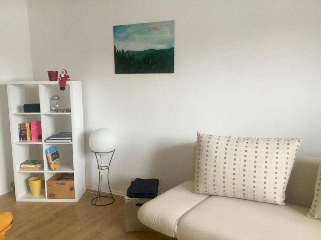 een woonkamer met een bank en een boekenplank bij Ferienwohnung Keilbergblick in Kurort Oberwiesenthal