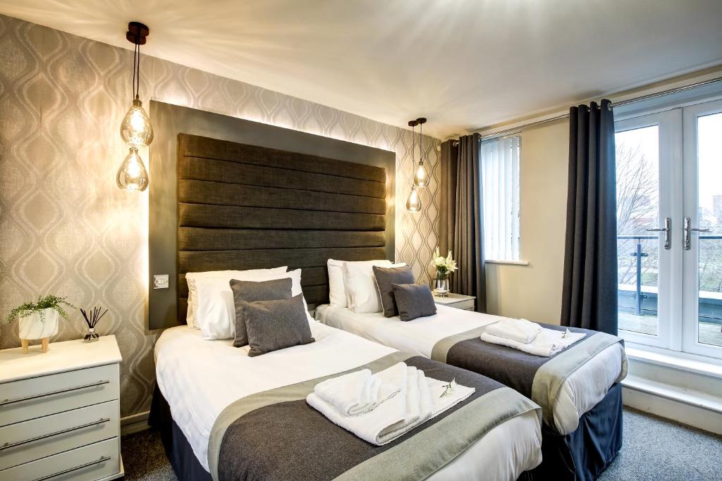 a hotel room with two beds and a window at Riverside Villas in Manchester