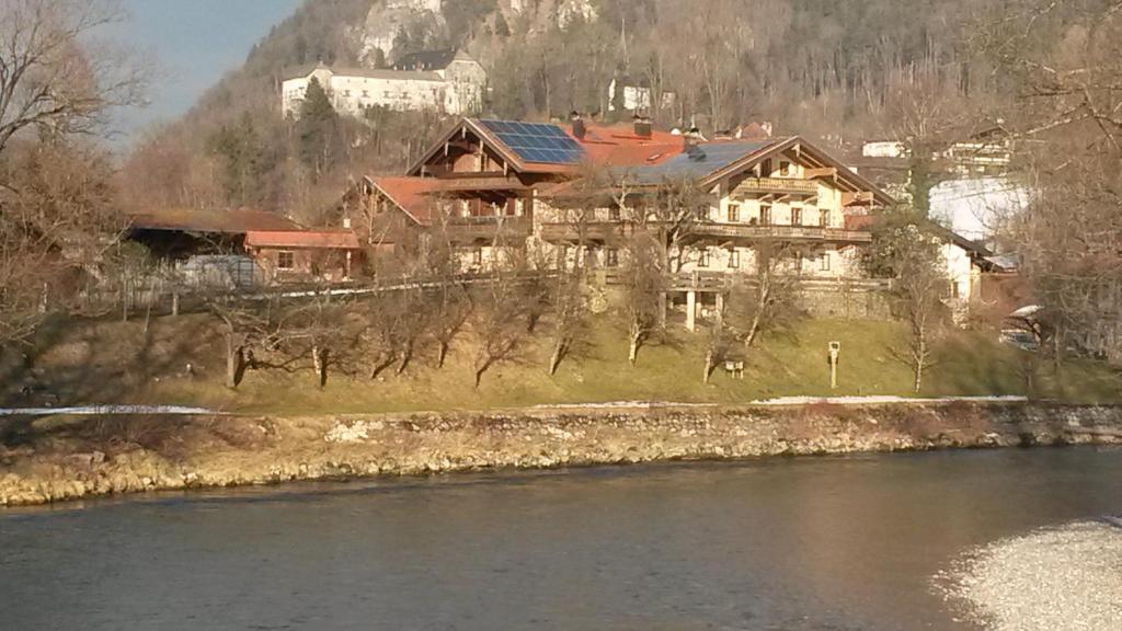una casa grande sentada a orillas de un río en Ferienwohnung Haus Wuhrbichl, en Marquartstein