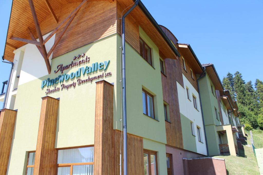 a building with a sign on the side of it at Pine Wood Apartment in Vyšné Ružbachy