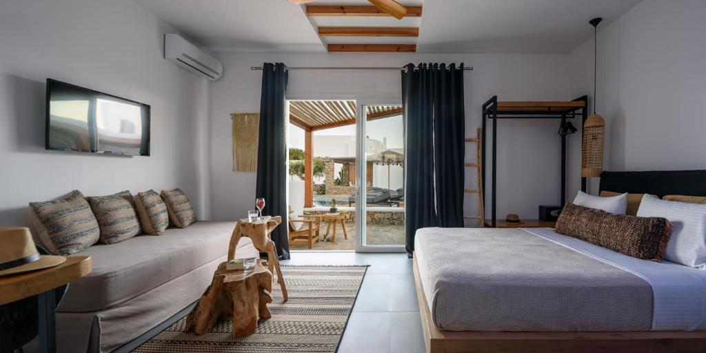 Un dormitorio con una cama y un sofá en una habitación. en Olive Mykonos Villas, en Ano Mera