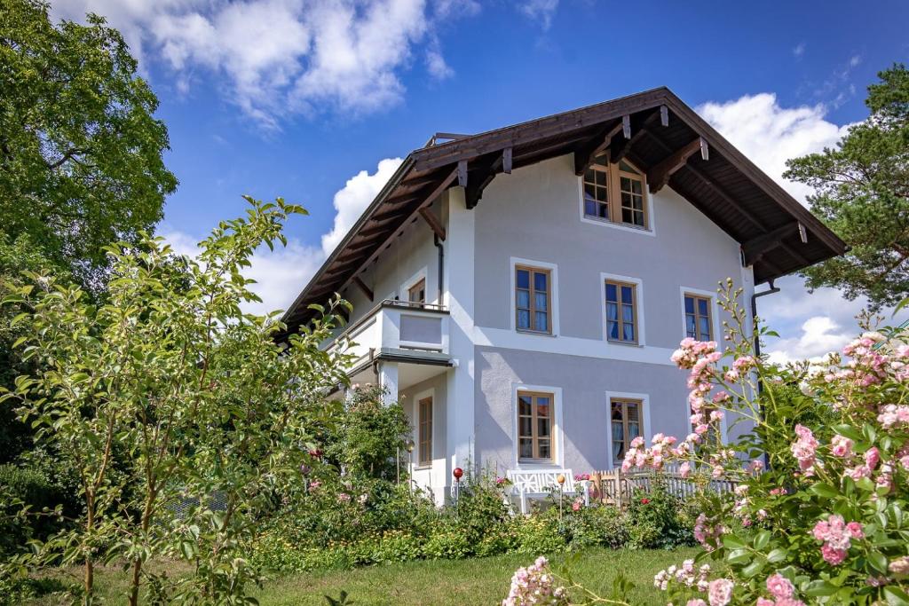 a white house with flowers in front of it at Ferienwohnung Adlmaier in Chieming