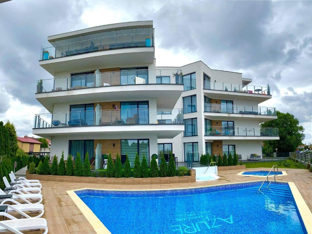 a large building with a swimming pool in front of it at AZURE PREMIUM Dreams in Kołobrzeg