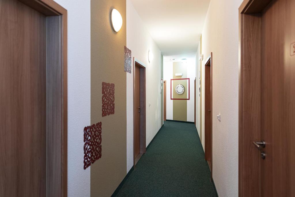 a corridor of a hallway with a green floor at Hotel Polonia - Frankfurt&#47;Oder in Frankfurt Oder