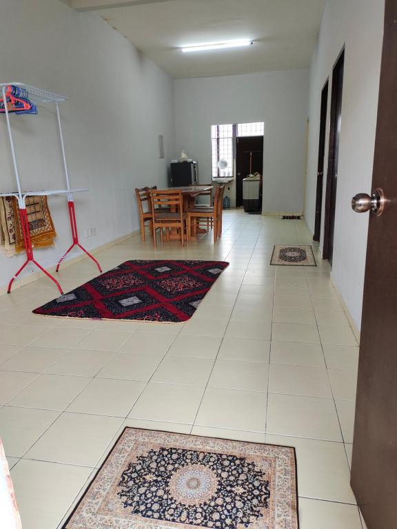 ein Wohnzimmer mit 2 Teppichen auf dem Boden in der Unterkunft Rosdan Homestay in Bachok