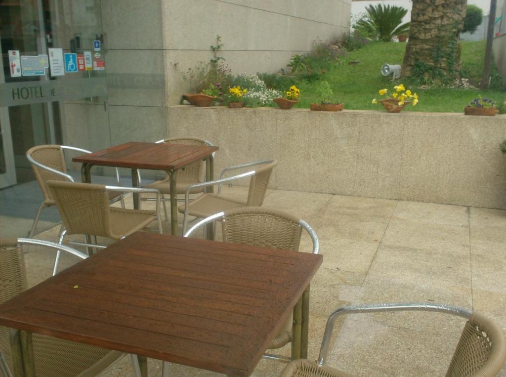 two tables and chairs in a patio with flowers at Hotel De Cerva in Cerva