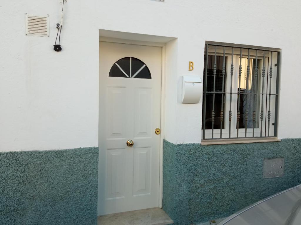 une porte blanche sur un mur avec une fenêtre dans l'établissement Miguel y Rosa 2, à Tíjola
