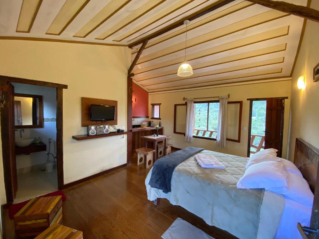 a bedroom with a large bed in a room at Chalé Serra dos Encantos in Lavras Novas