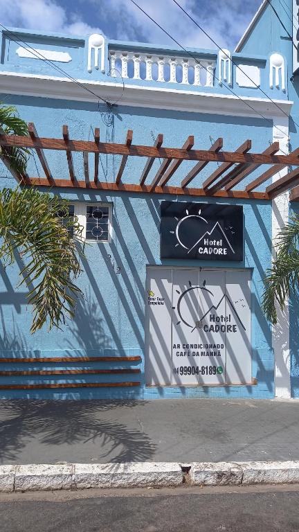 a blue building with a sign on the side of it at Hotel Cadore in Bauru